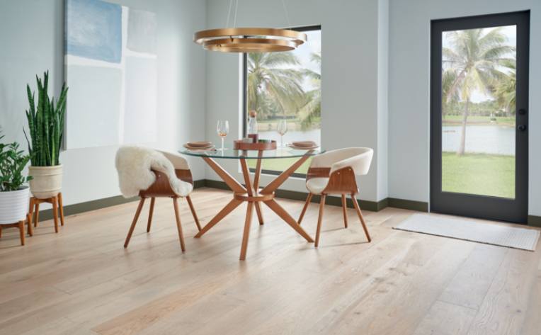 warm toned hardwood flooring in dining room with wood and glass table and wood chairs.